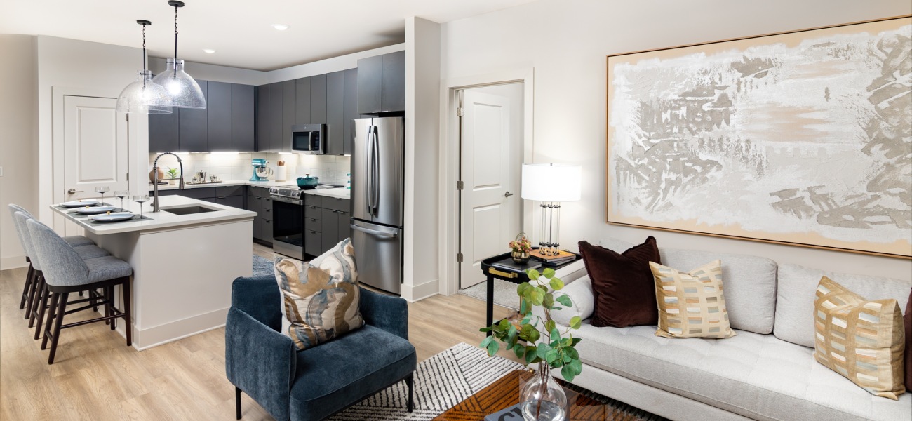 elan satellite apartment living area kitchen island in view barstools pendant lighting wall art sofa chair