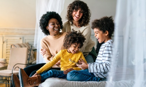 multi generational family smiling laughing sitting looking at tablet